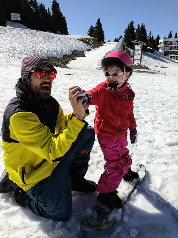 jeune enfant sur son snowboard avec le moniteur diplomé d'état